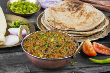 Hint mutfağı Sev Tamaeta ya da Sev Tameta da Chapati, Papad, Onion ya da Raita ile servis edilir. Domatesli ve soğan soslu, ahşap masa üzerinde baharatlı Sev soslu.