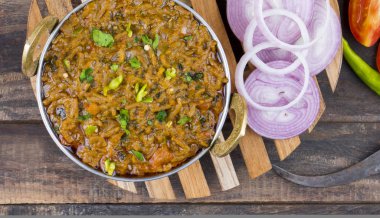 Hint mutfağı Sev Tamaeta ya da Sev Tameta da Chapati, Papad, Onion ya da Raita ile servis edilir. Domatesli ve soğan soslu, ahşap masa üzerinde baharatlı Sev soslu.