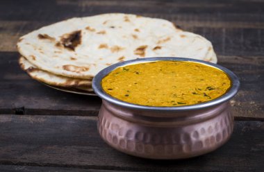 Hint Vejetaryen Mutfağı Dal Makhani, Dal Makhni ya da Daal Makhani olarak da bilinir, Pencap 'tan getirilmiş, siyah mercimek, kırmızı böbrek fasulyesi, tereyağı ve kremayla pişirilmiş popüler bir yemektir. Eski Ahşap Arkaplanda