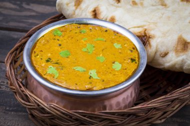 Hint Vejetaryen Mutfağı Dal Makhani, Dal Makhni ya da Daal Makhani olarak da bilinir, Pencap 'tan getirilmiş, siyah mercimek, kırmızı böbrek fasulyesi, tereyağı ve kremayla pişirilmiş popüler bir yemektir. Eski Ahşap Arkaplanda