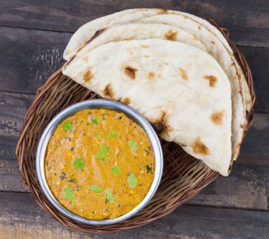 Hint Vejetaryen Mutfağı Dal Makhani, Dal Makhni ya da Daal Makhani olarak da bilinir, Pencap 'tan getirilmiş, siyah mercimek, kırmızı böbrek fasulyesi, tereyağı ve kremayla pişirilmiş popüler bir yemektir. Eski Ahşap Arkaplanda