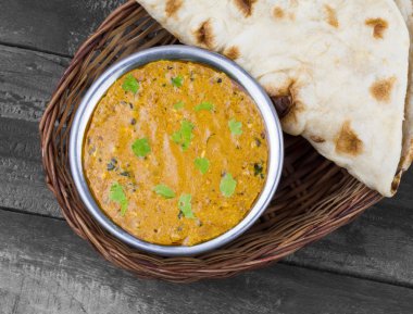 Hint Vejetaryen Mutfağı Dal Makhani, Dal Makhni ya da Daal Makhani olarak da bilinir, Pencap 'tan getirilmiş, siyah mercimek, kırmızı böbrek fasulyesi, tereyağı ve kremayla pişirilmiş popüler bir yemektir. Eski Ahşap Arkaplanda