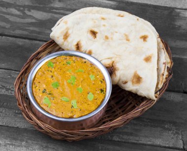 Hint Vejetaryen Mutfağı Dal Makhani, Dal Makhni ya da Daal Makhani olarak da bilinir, Pencap 'tan getirilmiş, siyah mercimek, kırmızı böbrek fasulyesi, tereyağı ve kremayla pişirilmiş popüler bir yemektir. Eski Ahşap Arkaplanda