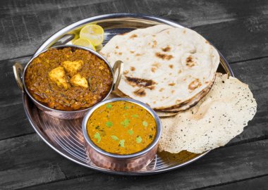 Hint Geleneksel Thali Food Dal Makhani Chapati, Papad, Kadai Paneer veya Lemon Also Know ile birlikte Dal Makhni veya Daal Makhani olarak hizmet vermektedir. Eski Ahşap Arkaplanda