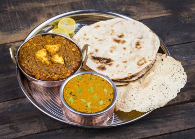 Hint Geleneksel Thali Food Dal Makhani Chapati, Papad, Kadai Paneer veya Lemon Also Know ile birlikte Dal Makhni veya Daal Makhani olarak hizmet vermektedir. Eski Ahşap Arkaplanda