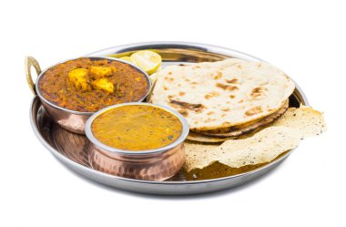 Hint Geleneksel Thali Food Dal Makhani Chapati, Papad, Kadai Paneer veya Lemon Also Know ile birlikte Dal Makhni veya Daal Makhani olarak hizmet vermektedir. Beyaz Arkaplanda izole edilmiş
