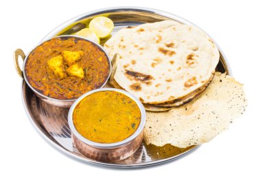 Hint Geleneksel Thali Food Dal Makhani Chapati, Papad, Kadai Paneer veya Lemon Also Know ile birlikte Dal Makhni veya Daal Makhani olarak hizmet vermektedir. Beyaz Arkaplanda izole edilmiş