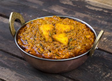 Hint Vejetaryen Mutfağı Kadai Paneer Kadhai Paneer ya da Karahi Paneer olarak da bilinir, eski ahşap arka planda baharatlı bir sos ile servis edilen bir Hint Marinated Paneer Peynir Tabağı.