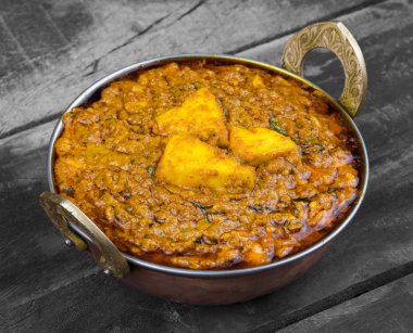 Hint Vejetaryen Mutfağı Kadai Paneer Kadhai Paneer ya da Karahi Paneer olarak da bilinir, eski ahşap arka planda baharatlı bir sos ile servis edilen bir Hint Marinated Paneer Peynir Tabağı.