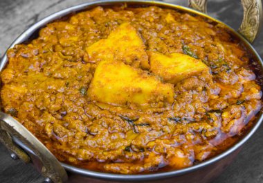 Hint Vejetaryen Mutfağı Kadai Paneer Kadhai Paneer ya da Karahi Paneer olarak da bilinir, eski ahşap arka planda baharatlı bir sos ile servis edilen bir Hint Marinated Paneer Peynir Tabağı.