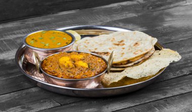 Hint Geleneksel Thali Food Dal Makhani Chapati, Papad, Kadai Paneer veya Lemon Also Know ile birlikte Dal Makhni veya Daal Makhani olarak hizmet vermektedir. Eski Ahşap Arkaplanda