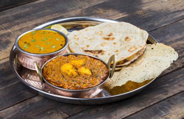 Hint Geleneksel Thali Food Dal Makhani Chapati, Papad, Kadai Paneer veya Lemon Also Know ile birlikte Dal Makhni veya Daal Makhani olarak hizmet vermektedir. Eski Ahşap Arkaplanda