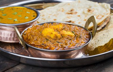 Hint Geleneksel Thali Food Dal Makhani Chapati, Papad, Kadai Paneer veya Lemon Also Know ile birlikte Dal Makhni veya Daal Makhani olarak hizmet vermektedir. Eski Ahşap Arkaplanda
