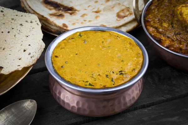 Hint Vejetaryen Mutfağı Dal Makhani, Dal Makhni ya da Daal Makhani olarak da bilinir, Pencap 'tan getirilmiş, siyah mercimek, kırmızı böbrek fasulyesi, tereyağı ve kremayla pişirilmiş popüler bir yemektir. Eski Ahşap Arkaplanda