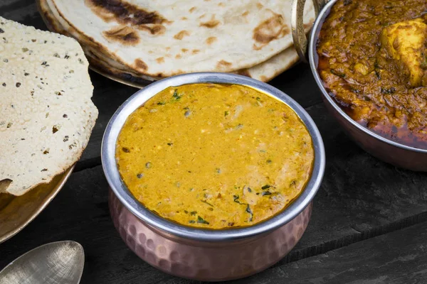 Hint Vejetaryen Mutfağı Dal Makhani, Dal Makhni ya da Daal Makhani olarak da bilinir, Pencap 'tan getirilmiş, siyah mercimek, kırmızı böbrek fasulyesi, tereyağı ve kremayla pişirilmiş popüler bir yemektir. Eski Ahşap Arkaplanda