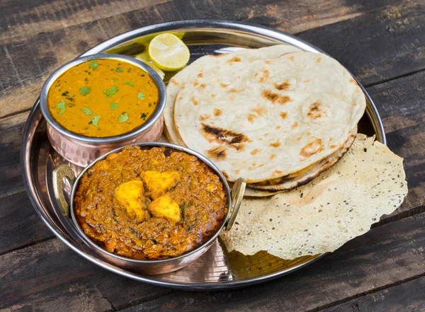 Hint Geleneksel Thali Food Dal Makhani Chapati, Papad, Kadai Paneer veya Lemon Also Know ile birlikte Dal Makhni veya Daal Makhani olarak hizmet vermektedir. Eski Ahşap Arkaplanda