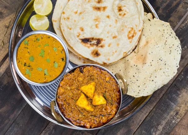 Hint Geleneksel Thali Food Dal Makhani Chapati, Papad, Kadai Paneer veya Lemon Also Know ile birlikte Dal Makhni veya Daal Makhani olarak hizmet vermektedir. Eski Ahşap Arkaplanda