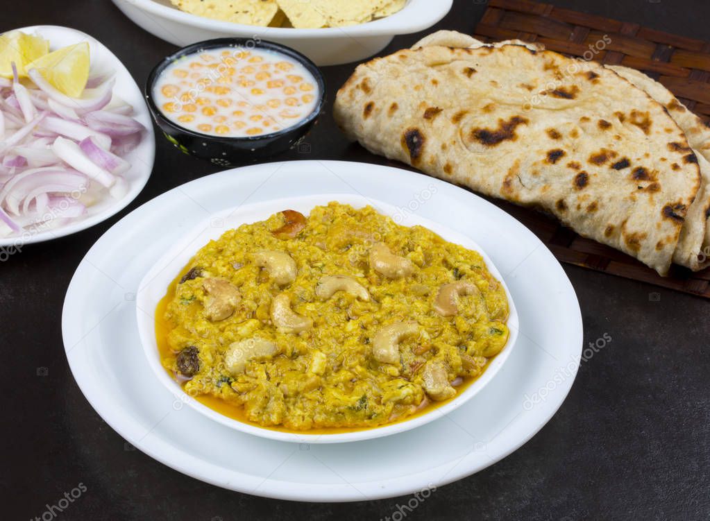 Indian Traditional Vegetarian Cuisine Kaju Curry Also Called Kaju Butter Masala Served with Tandoori Roti, Raita, Salad And Papad