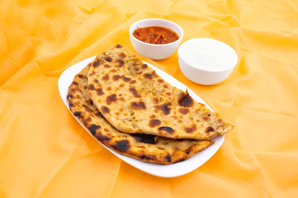 Hint Geleneksel Kahvaltı Tabağı Aloo Paratha taze krema ve turşuyla servis edilen bir patates dolgulu ekmek.
