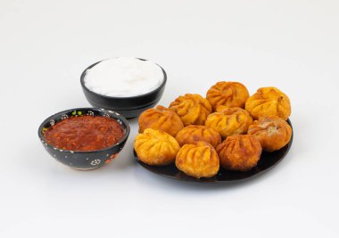 Kızarmış Momos, Nepal 'den geleneksel bir hamur yemeğidir. Schezwan Sosu ve Krema ile servis edilir.