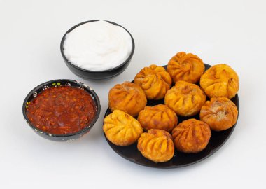 Kızarmış Momos, Nepal 'den geleneksel bir hamur yemeğidir. Schezwan Sosu ve Krema ile servis edilir.