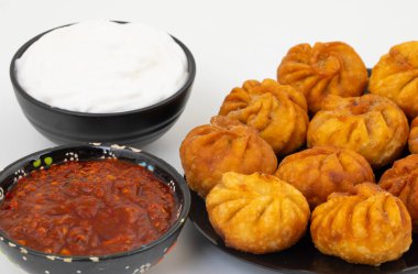 Kızarmış Momos, Nepal 'den geleneksel bir hamur yemeğidir. Schezwan Sosu ve Krema ile servis edilir.
