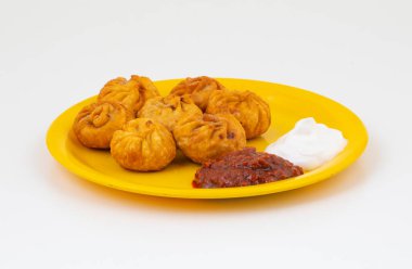 Kızarmış Momos, Nepal 'den geleneksel bir hamur yemeğidir. Schezwan Sosu ve Krema ile servis edilir.