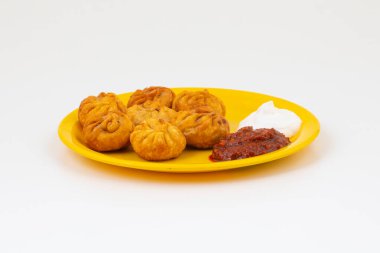 Kızarmış Momos, Nepal 'den geleneksel bir hamur yemeğidir. Schezwan Sosu ve Krema ile servis edilir.
