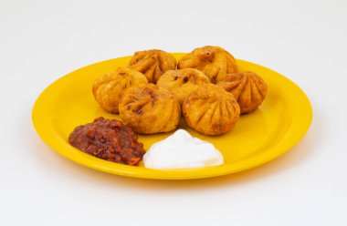 Kızarmış Momos, Nepal 'den geleneksel bir hamur yemeğidir. Schezwan Sosu ve Krema ile servis edilir.