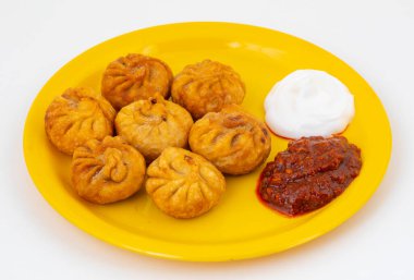 Kızarmış Momos, Nepal 'den geleneksel bir hamur yemeğidir. Schezwan Sosu ve Krema ile servis edilir.