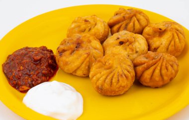 Kızarmış Momos, Nepal 'den geleneksel bir hamur yemeğidir. Schezwan Sosu ve Krema ile servis edilir.