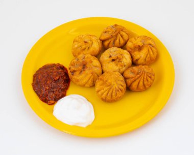Kızarmış Momos, Nepal 'den geleneksel bir hamur yemeğidir. Schezwan Sosu ve Krema ile servis edilir.