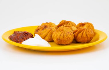 Kızarmış Momos, Nepal 'den geleneksel bir hamur yemeğidir. Schezwan Sosu ve Krema ile servis edilir.
