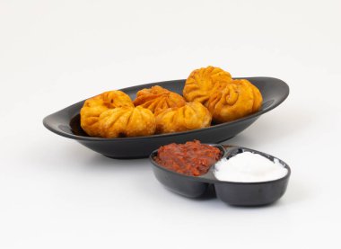 Kızarmış Momos, Nepal 'den geleneksel bir hamur yemeğidir. Schezwan Sosu ve Krema ile servis edilir.