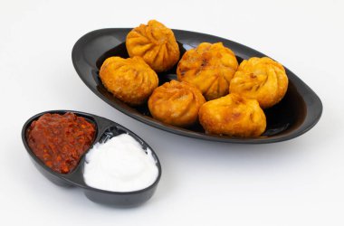 Kızarmış Momos, Nepal 'den geleneksel bir hamur yemeğidir. Schezwan Sosu ve Krema ile servis edilir.