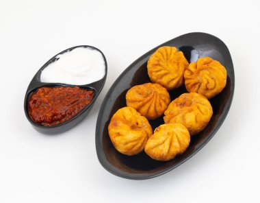 Kızarmış Momos, Nepal 'den geleneksel bir hamur yemeğidir. Schezwan Sosu ve Krema ile servis edilir.