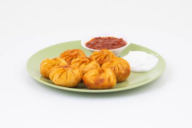Kızarmış Momos, Nepal 'den geleneksel bir hamur yemeğidir. Schezwan Sosu ve Krema ile servis edilir.