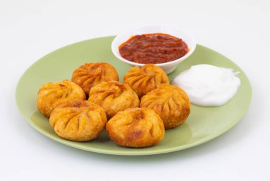 Kızarmış Momos, Nepal 'den geleneksel bir hamur yemeğidir. Schezwan Sosu ve Krema ile servis edilir.