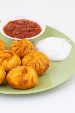 Kızarmış Momos, Nepal 'den geleneksel bir hamur yemeğidir. Schezwan Sosu ve Krema ile servis edilir.