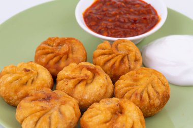 Kızarmış Momos, Nepal 'den geleneksel bir hamur yemeğidir. Schezwan Sosu ve Krema ile servis edilir.