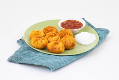 Kızarmış Momos, Nepal 'den geleneksel bir hamur yemeğidir. Schezwan Sosu ve Krema ile servis edilir.