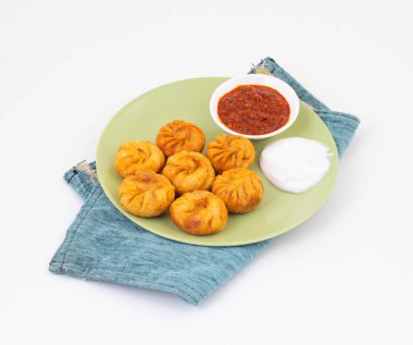 Kızarmış Momos, Nepal 'den geleneksel bir hamur yemeğidir. Schezwan Sosu ve Krema ile servis edilir.