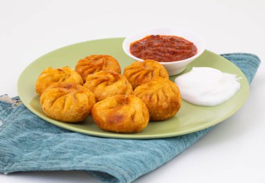 Kızarmış Momos, Nepal 'den geleneksel bir hamur yemeğidir. Schezwan Sosu ve Krema ile servis edilir.