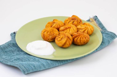 Kızarmış Momos, Nepal 'den geleneksel bir hamur yemeğidir. Schezwan Sosu ve Krema ile servis edilir.