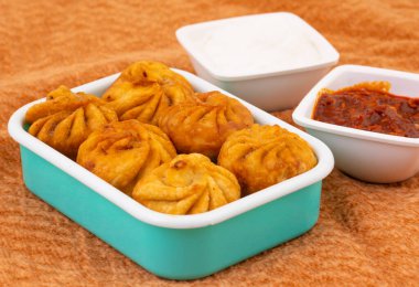 Kızarmış Momos, Nepal 'den geleneksel bir hamur yemeğidir. Schezwan Sosu ve Krema ile servis edilir.