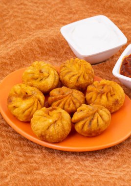 Kızarmış Momos, Nepal 'den geleneksel bir hamur yemeğidir. Schezwan Sosu ve Krema ile servis edilir.