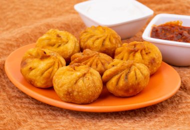 Kızarmış Momos, Nepal 'den geleneksel bir hamur yemeğidir. Schezwan Sosu ve Krema ile servis edilir.