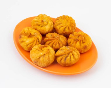 Kızarmış Momos, Nepal 'den geleneksel bir hamur yemeğidir. Schezwan Sosu ve Krema ile servis edilir.