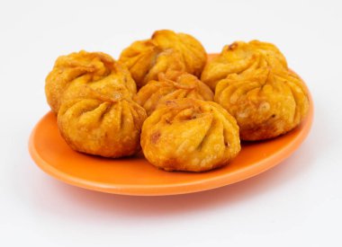 Kızarmış Momos, Nepal 'den geleneksel bir hamur yemeğidir. Schezwan Sosu ve Krema ile servis edilir.