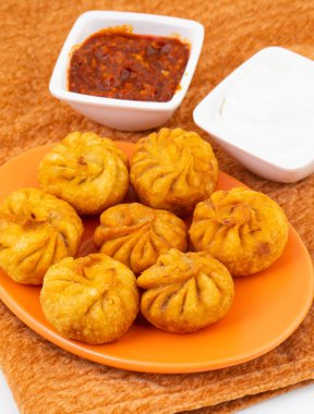 Kızarmış Momos, Nepal 'den geleneksel bir hamur yemeğidir. Schezwan Sosu ve Krema ile servis edilir.